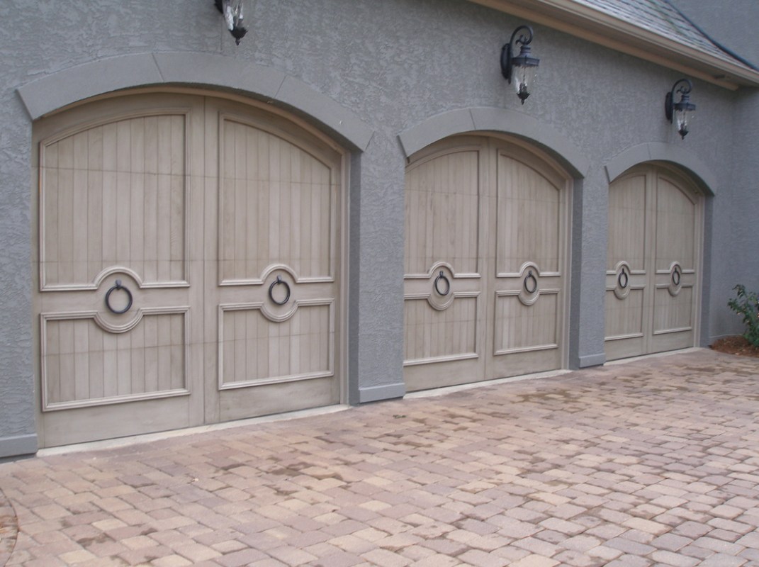 Custom wood beige garage doors against gray wall